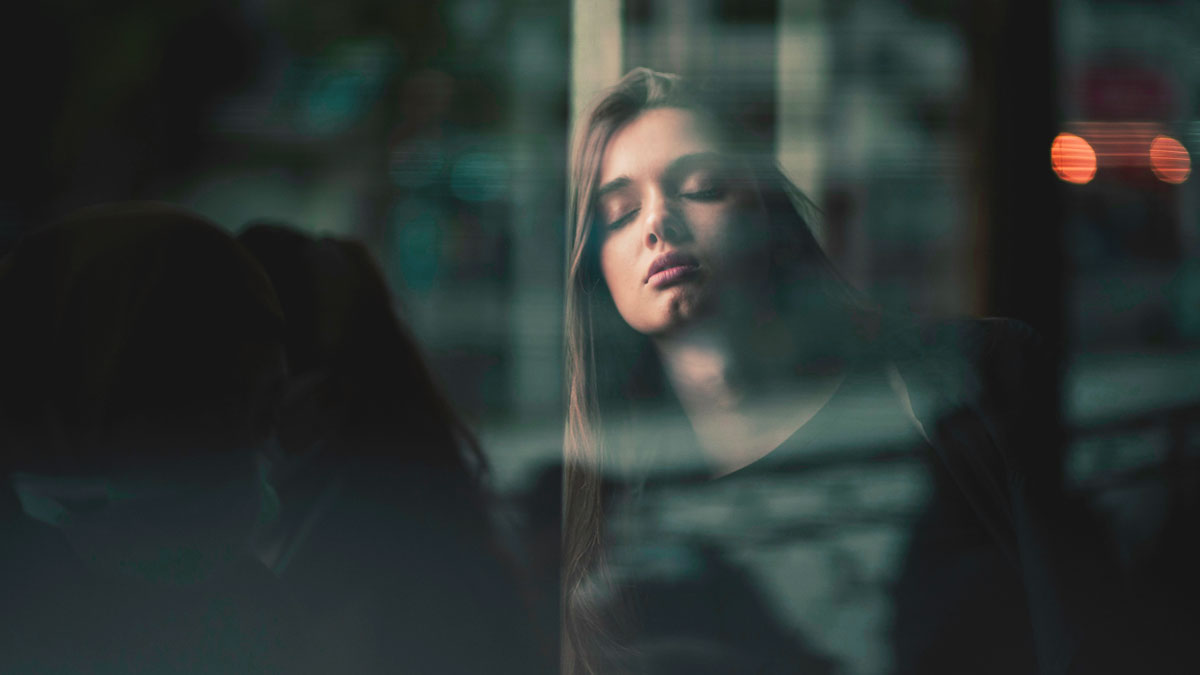 恋愛や人生に悩み、カフェの窓辺でモヤモヤしている30代女性