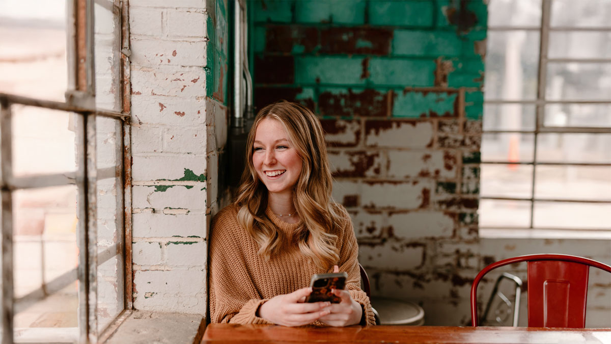 電話占いの初回無料特典をスマホで賢く活用し、笑顔で未来を想像する女性。失敗しないための使い方を解説